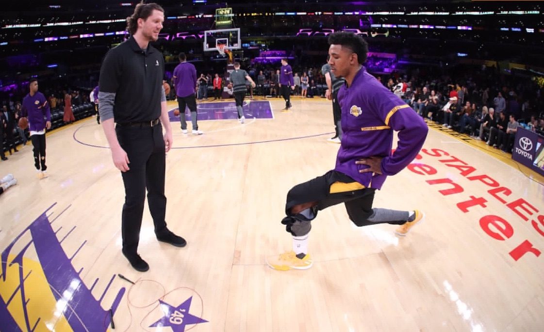 A coach guiding a professional basketball player through a left-side repositioning drill on court